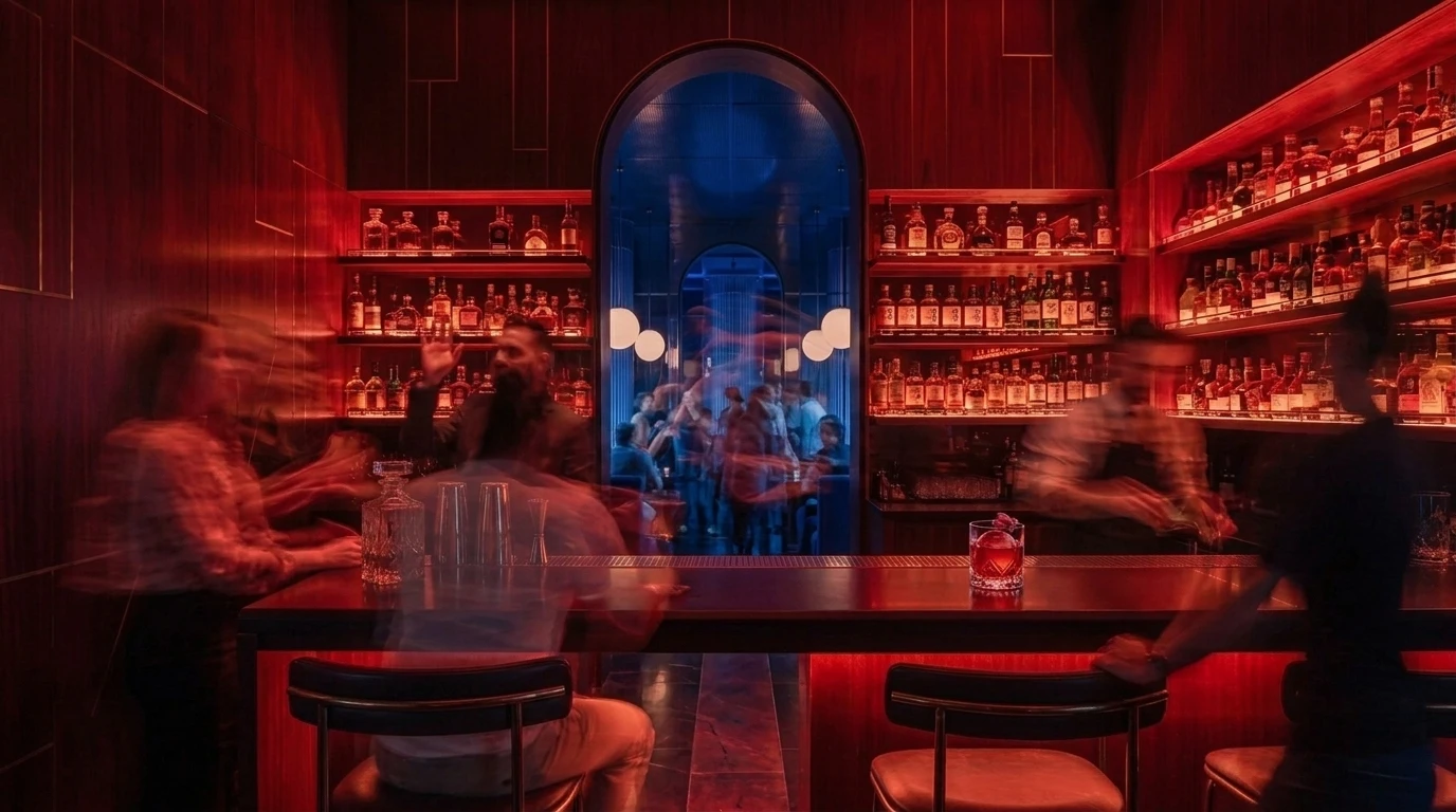 Mujize's crimson bar glows beside the cobalt room as bartenders work behind the counter.