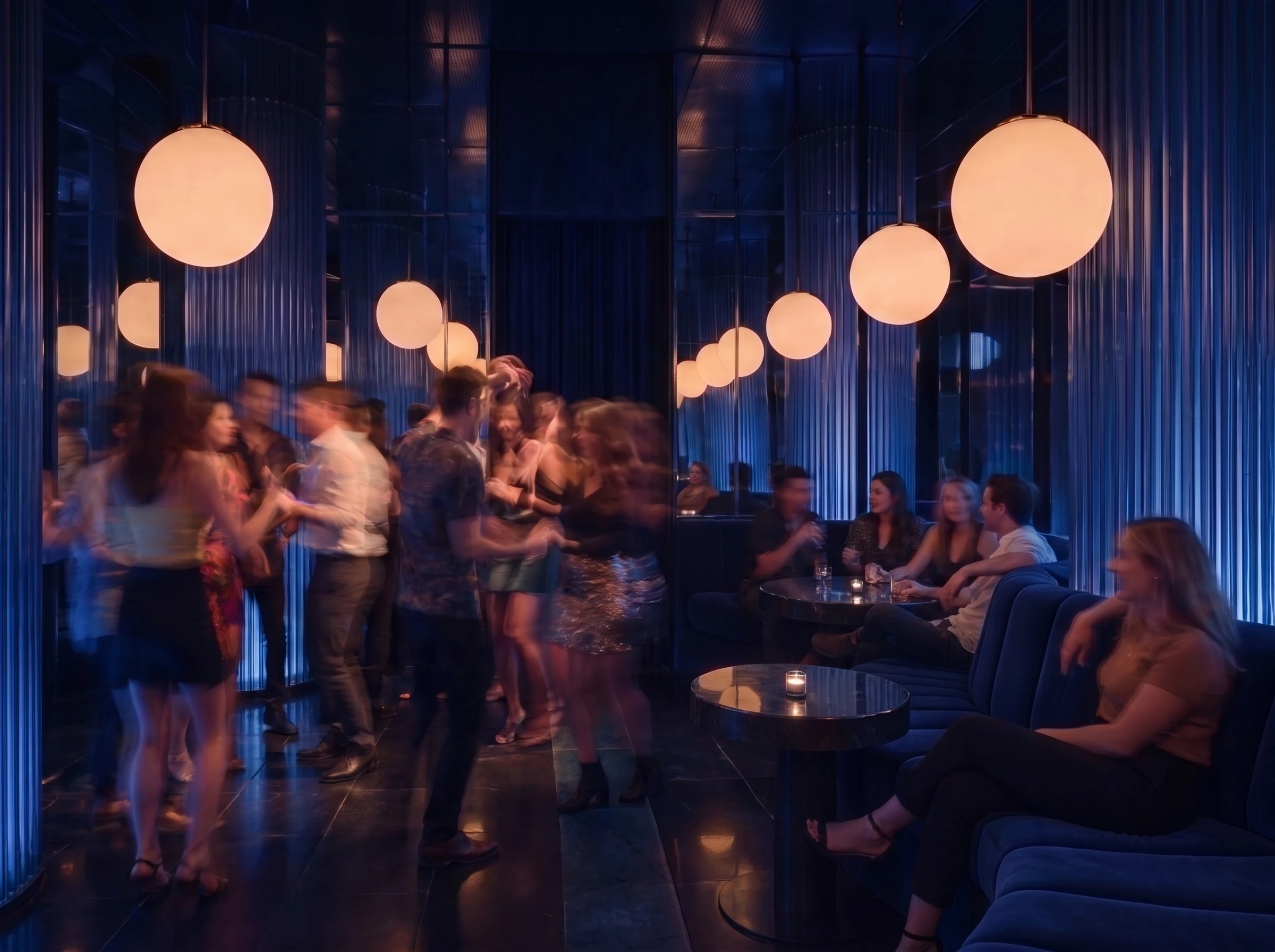 Guests gather and move through Mujize's mirrored cobalt room beneath glowing opal globes.